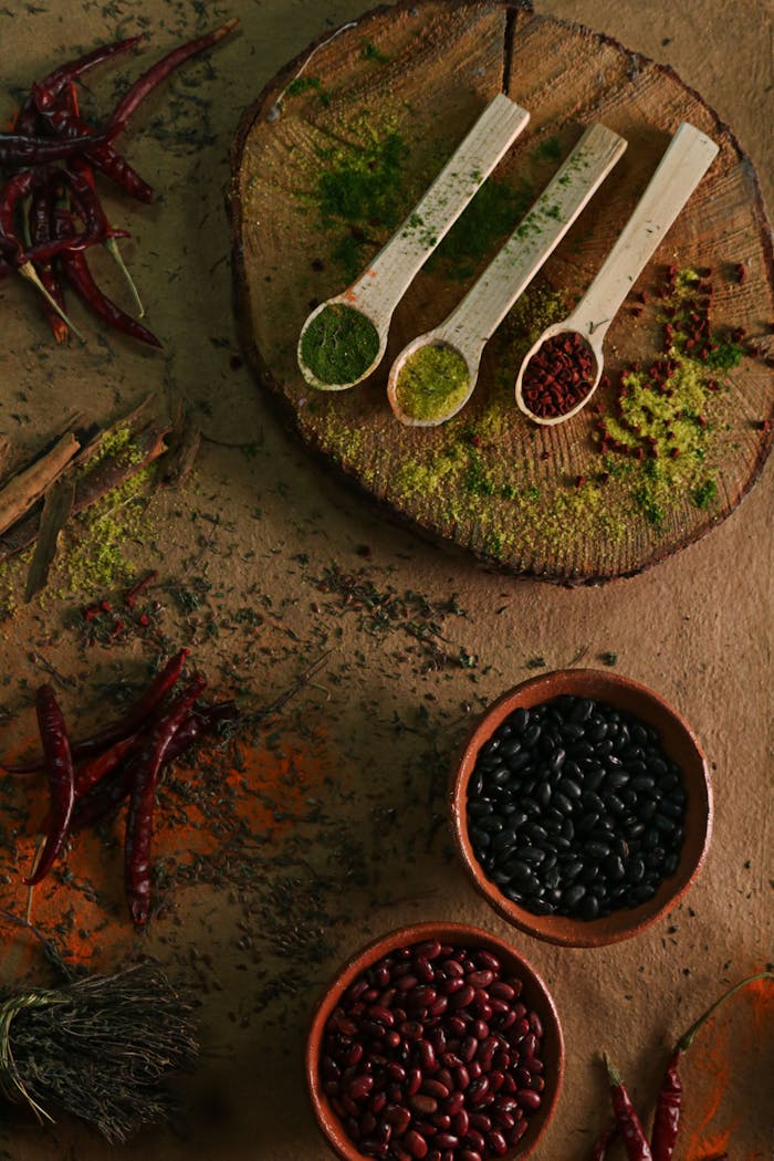 The Art of Drawing Readers In: Your attractive post title goes here A top-down view of various spices and beans arranged on a rustic wooden surface for culinary art.